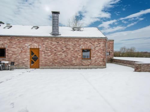 un edificio de ladrillo con un patio cubierto de nieve en Beautiful Holiday Home in Cul des Sarts with Garden, en Cul-des-Sarts