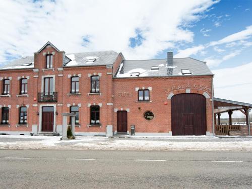 a large red brick building with a large door at Beautiful Holiday Home in Cul des Sarts with Garden in Cul-des-Sarts