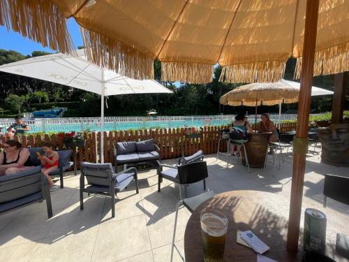 eine Terrasse mit Sonnenschirmen und einem Pool in der Unterkunft Le rayon vert in Six-Fours-les-Plages