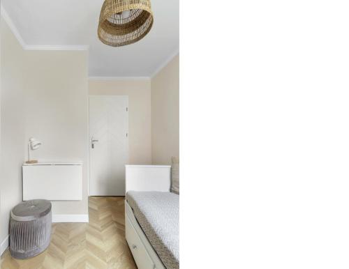 two views of a bedroom with a bed and a stool at Elite Apartments Center Superior in Gdańsk