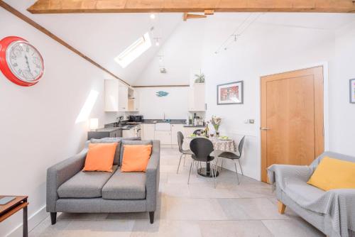 a living room with two chairs and a table at Kipper Cottage, Southwold in Southwold