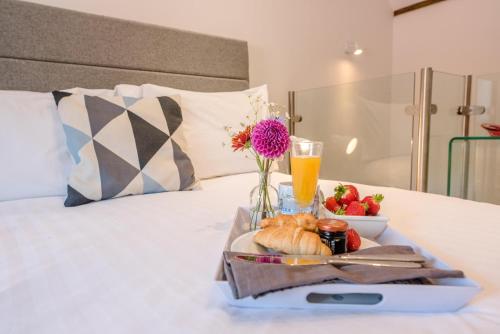 ein Tablett mit Essen auf einem Bett mit einem Teller. in der Unterkunft Kipper Cottage, Southwold in Southwold