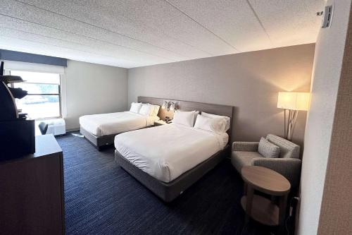 a hotel room with two beds and a couch at Wingate by Wyndham Waynesboro in Waynesboro