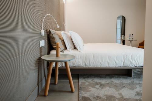 a bedroom with a bed and a small table at Biancodonda Greenblu Hotel & SPA in Gallipoli