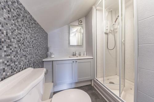 ein weißes Bad mit einem Waschbecken und einer Dusche in der Unterkunft Meadowdore Stay B&B in Coniston