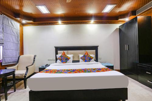 a bedroom with a large bed and a table at FabHotel Blue Moon Home Stay in New Delhi