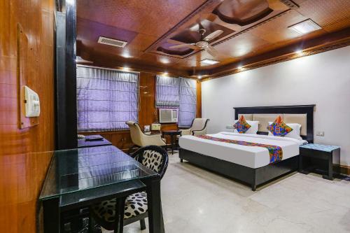 a bedroom with a bed and a table and a desk at FabHotel Blue Moon Home Stay in New Delhi