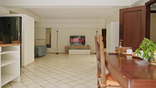 a living room with a table and a tv at Taormina 5 stars - Villa 5 minutes from the beach in Riposto