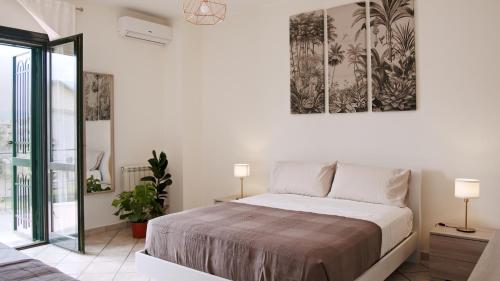 een slaapkamer met een bed en een schilderij aan de muur bij Taormina 5 stars - Villa 5 minutes from the beach in Riposto