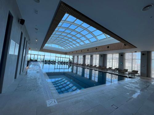a swimming pool in a building with a glass ceiling at Barakah Apartmets Batumi in Batumi