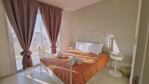ein Schlafzimmer mit einem Bett und einem großen Fenster in der Unterkunft STAY Mediterranean Waves Apartment in Paralimni