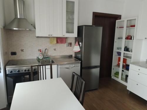 Una cocina con refrigerador de acero inoxidable y una mesa. en Casa Angi, en Florencia