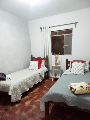 a room with two beds and a window at Casa simples em Diamantina in Diamantina