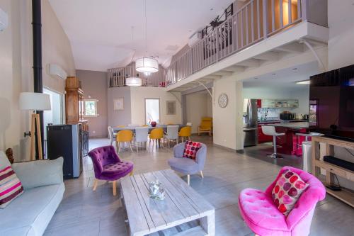 - un salon avec des chaises violettes et une table dans l'établissement La Villa d'Elvine - Maison avec grand jardin, à Verrie