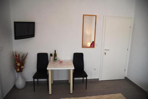 a dining room table with black chairs and a mirror at Villa Aurora in Međugorje