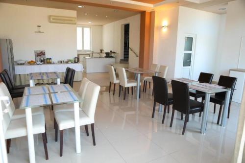 a dining room with tables and chairs and a kitchen at Villa Aurora in Međugorje
