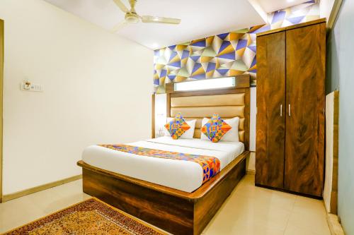 a small bedroom with a bed and a wooden cabinet at FabHotel Kwality Inn in Mumbai