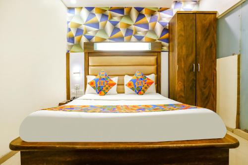 a bedroom with a large bed with a wooden headboard at FabHotel Kwality Inn in Mumbai