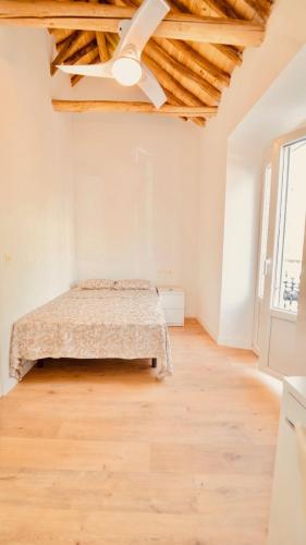 a bedroom with a bed and a wooden floor at Alojamiento Nevada in La Zubia