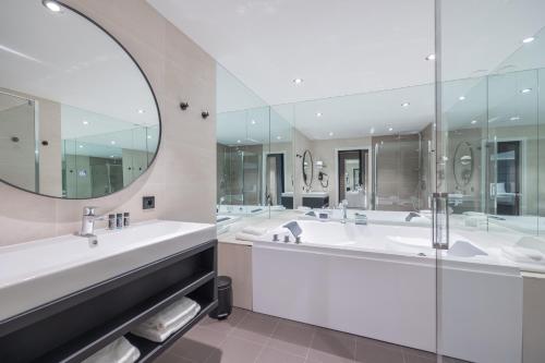 a bathroom with two sinks and a large mirror at Boutique Hotel Corona in The Hague