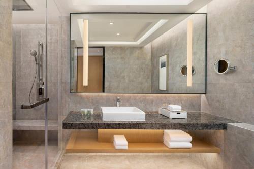 a bathroom with a sink and a mirror at Courtyard by Marriott Hangzhou West in Hangzhou