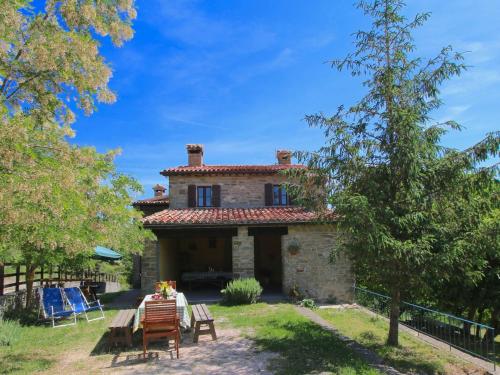 una casa de piedra con una mesa delante en Farmhouse in Apecchio with Swimming Pool Terrace Garden, en Apecchio