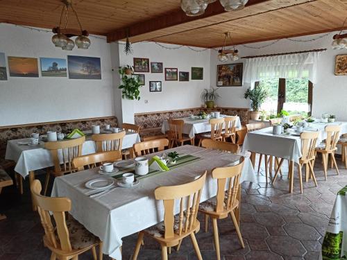 a dining room with white tables and chairs at Pension Dreiländereck in Birx