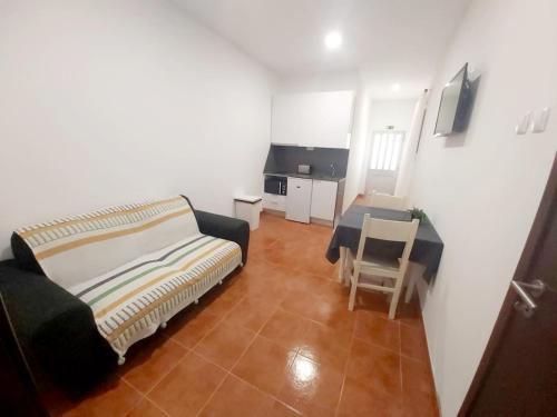 a bedroom with a bed and a table and a chair at Mateus Studios & Apartments - Duna Parque Group in Vila Nova de Milfontes