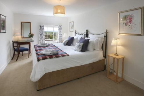 a bedroom with a large bed and a desk at Castle Cottage, Wadhurst in Wadhurst
