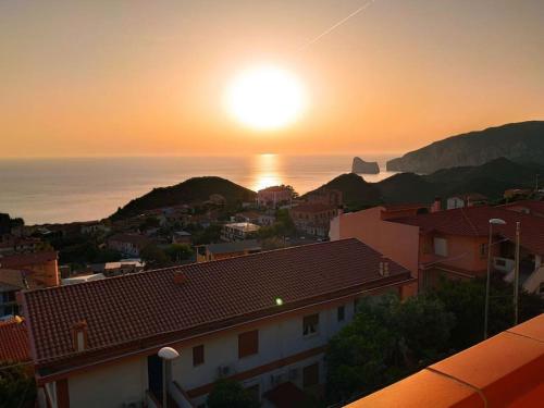 a sunset over a city with the ocean and buildings at Villa Mariuccia in Nebida