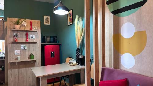 Hostel 13 في تبليسي: غرفة بطاولة وثلاجة حمراء
