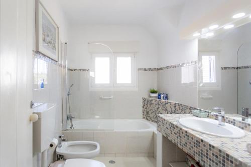 ein Badezimmer mit einer Badewanne, einem WC und einem Waschbecken in der Unterkunft Villa Lydia in Faro