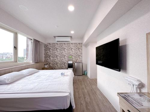 1 dormitorio con 1 cama grande y TV de pantalla plana en Meng Jing Hotel, en Zhongli