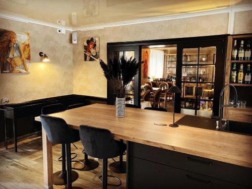 a bar with chairs and a wooden counter in a room at Hotel L'Ecrin 88 Vosges in Grandvillers