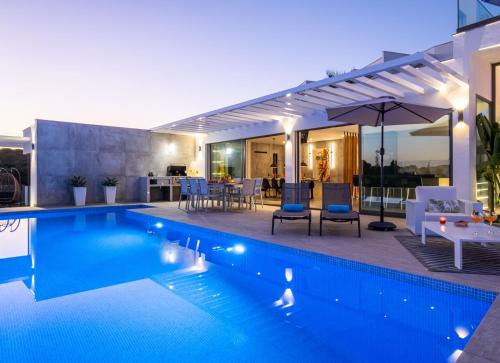 uma casa com piscina e guarda-sol em Villa Boa Vida by Algarve Vacation em Armação de Pêra