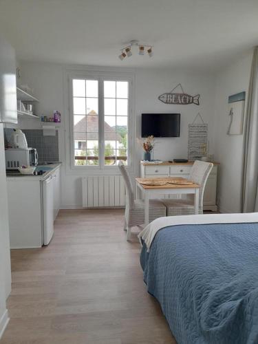 une chambre avec un lit et une table et une cuisine dans l'établissement Studio proche du centre ville et de la plage, à Villers-sur-Mer