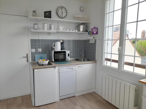 a kitchen with a sink and a microwave at Studio proche du centre ville et de la plage in Villers-sur-Mer