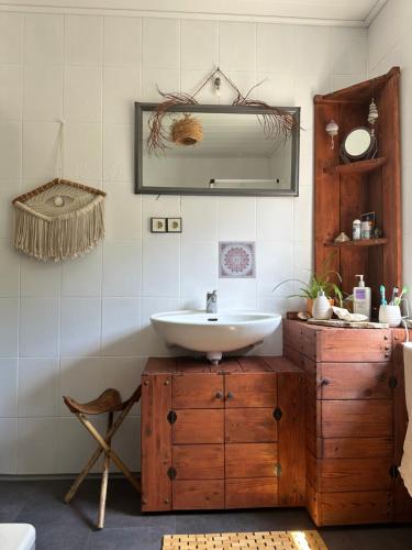 ein Bad mit einem Waschbecken und einem Spiegel in der Unterkunft Urlaubstraum am Brombachsee- 5 stilvolle Zimmer- in Pleinfeld