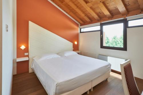 a bedroom with a white bed and two windows at Villa Martin Hotel in Dolo
