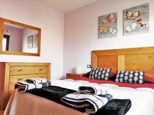 a bedroom with a bed with towels on it at Casa Armonia in Ávila