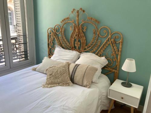 un letto con testiera decorata in una camera da letto di T2 climatisé dans l’hyper-centre de Marseille a Marsiglia