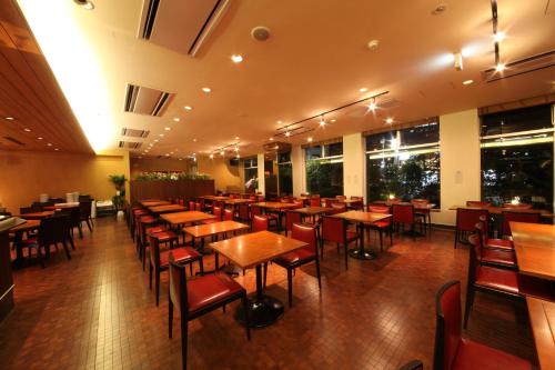 a restaurant with wooden tables and chairs and windows at Sun Days Kagoshima in Kagoshima