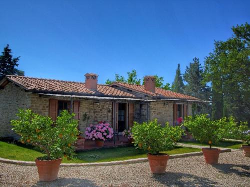 una casa con macetas delante de ella en Detached villa for 6 pers with outdoor swimming pool, en Loro Ciuffenna