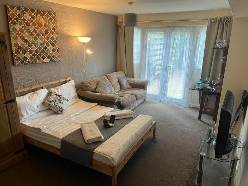 a living room with a bed and a couch at OAKhouse Raven in Basildon
