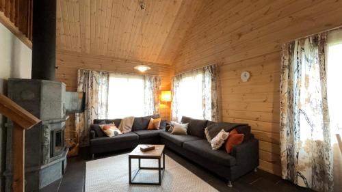 sala de estar con sofá y chimenea en Kantokelo, en Ylläsjärvi