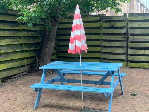 een blauwe picknicktafel met een paraplu erop bij OAKhouse Raven in Basildon