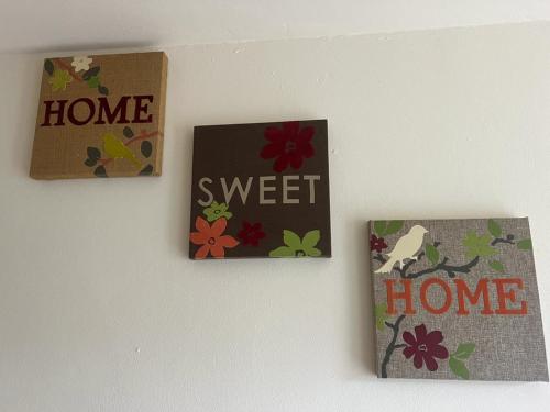 three signs on a wall with flowers on it at OAKhouse Raven in Basildon