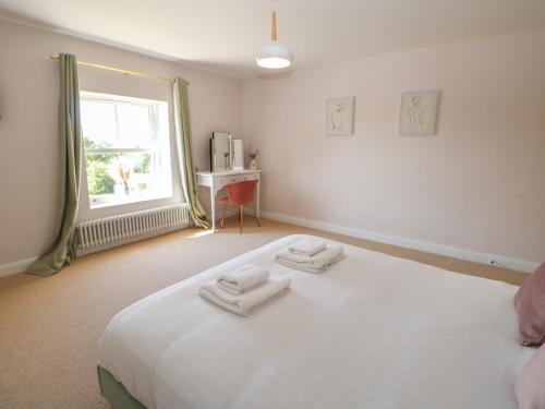 a bedroom with a large white bed with two towels on it at The Old House in Northallerton