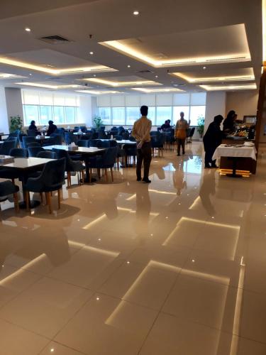 a group of people standing in a room with tables and chairs at Dolphin Continental Hotel in Kuwait