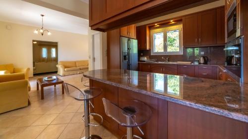 a kitchen with a counter and a living room at Villa Afrato in Kefallonia